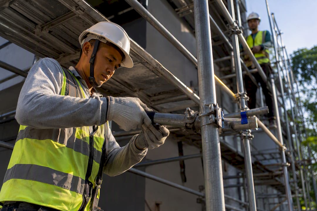 Worker assembling Singapore construction scaffold
