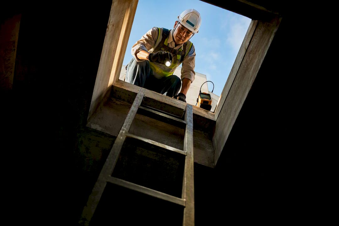 Safety officer assessing concrete chamber entry